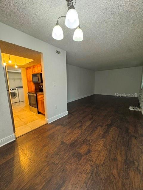 A view of a room with dark wood flooring leading into a kitchen area — 4735 S TEXAS AVENUE UNIT 4735C, ORLANDO, FL