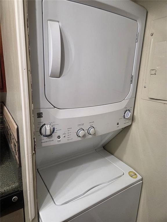 A white stacked washer and dryer unit is installed in a narrow laundry closet — 4326 AQUA VISTA DRIVE UNIT 10E, ORLANDO, FL
