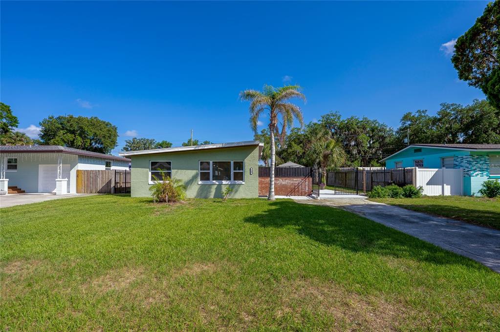 A light green single-story house with a palm tree and a concrete driveway — 723 STEELE AVENUE, SOUTH DAYTONA, FL