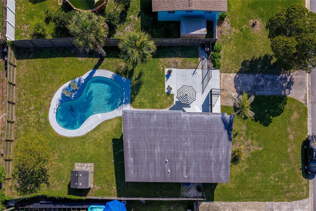 An aerial view shows a house with a backyard pool, patio, and a small shed — 723 STEELE AVENUE, SOUTH DAYTONA, FL