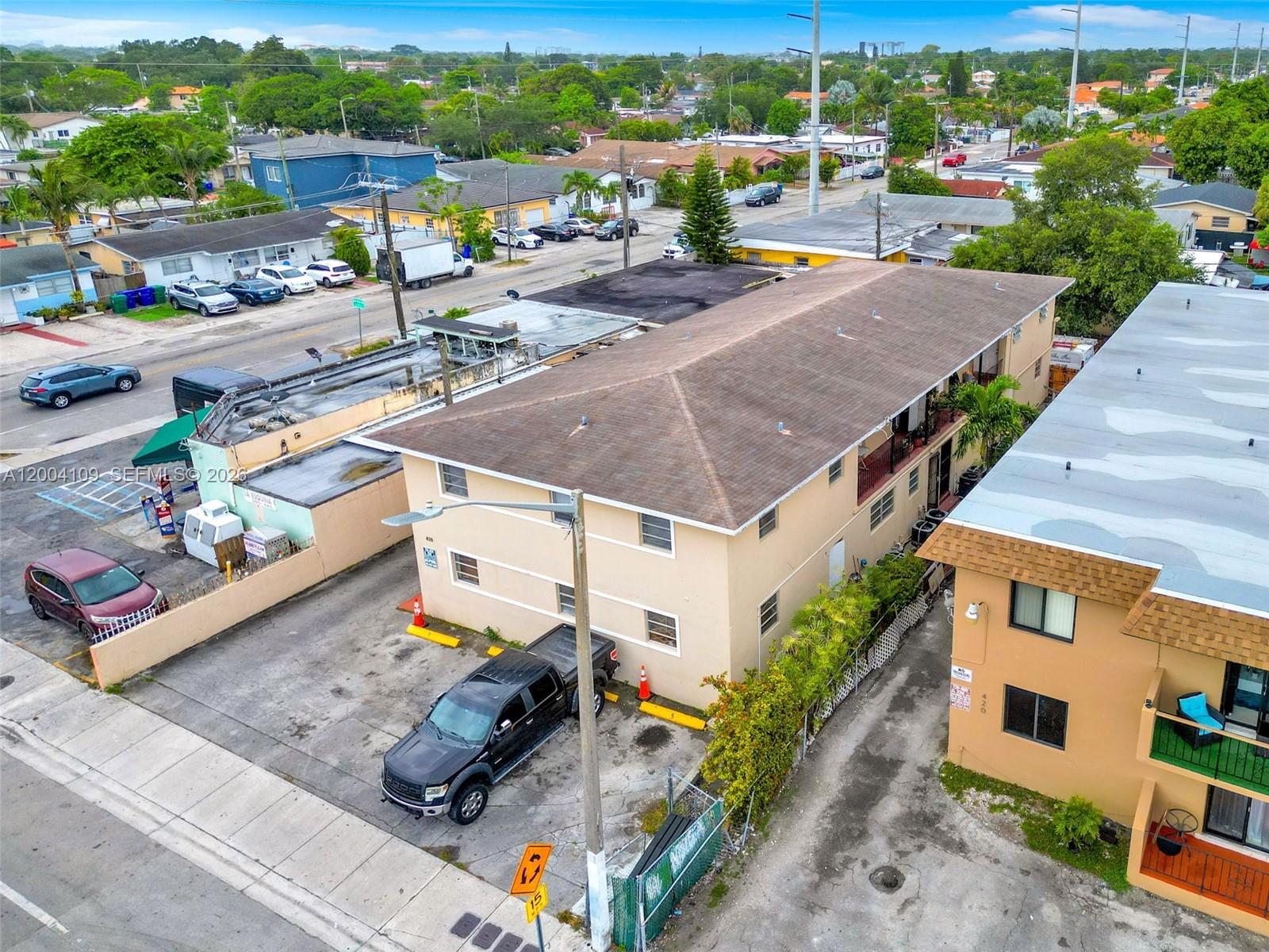 An aerial view shows a two-story tan apartment building with a parking lot and street — 410 NW 47th Ave, Miami FL 33126, MIAMI, FL