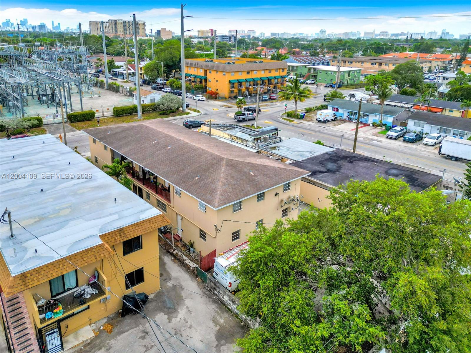 An aerial view shows two multi-story apartment buildings with parking and a nearby electrical substation — 410 NW 47th Ave, Miami FL 33126, MIAMI, FL