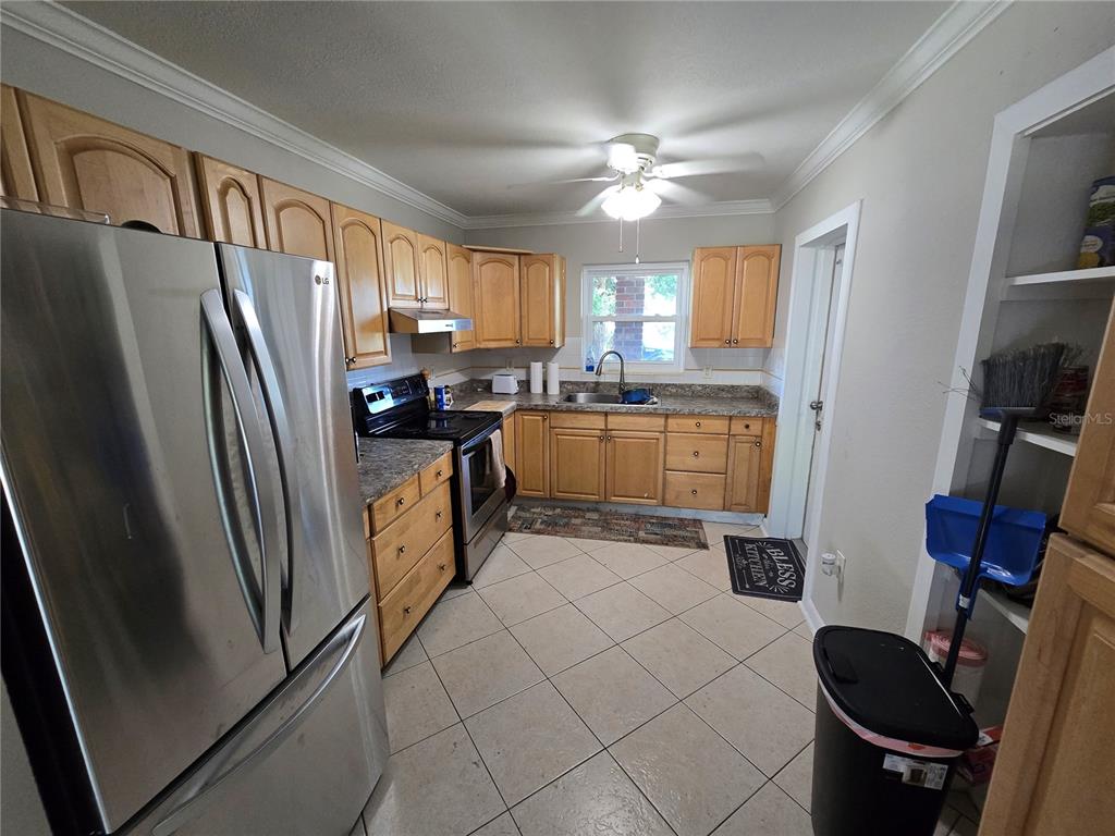A kitchen with light wood cabinets, stainless steel appliances, and tile flooring — 2456 EDNOR STREET, PORT CHARLOTTE, FL