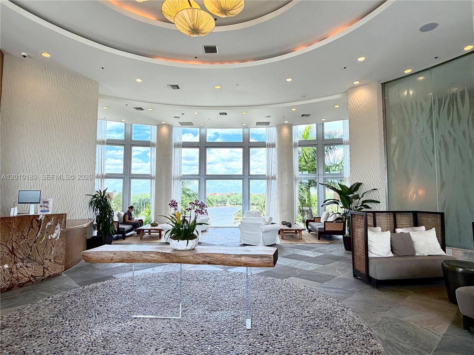 A spacious lobby features a circular floor design, floor-to-ceiling windows, and a water view — 2641 N Flamingo Rd, Sunrise FL 33323, SUNRISE, FL
