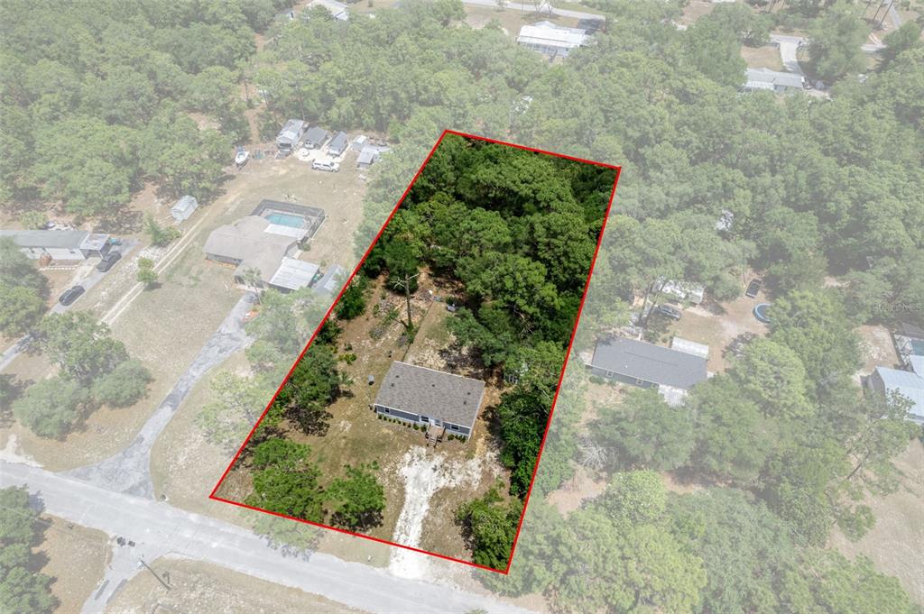 An aerial view shows a house on a wooded lot outlined in red — 2063 S SUNWOOD POINT, HOMOSASSA, FL