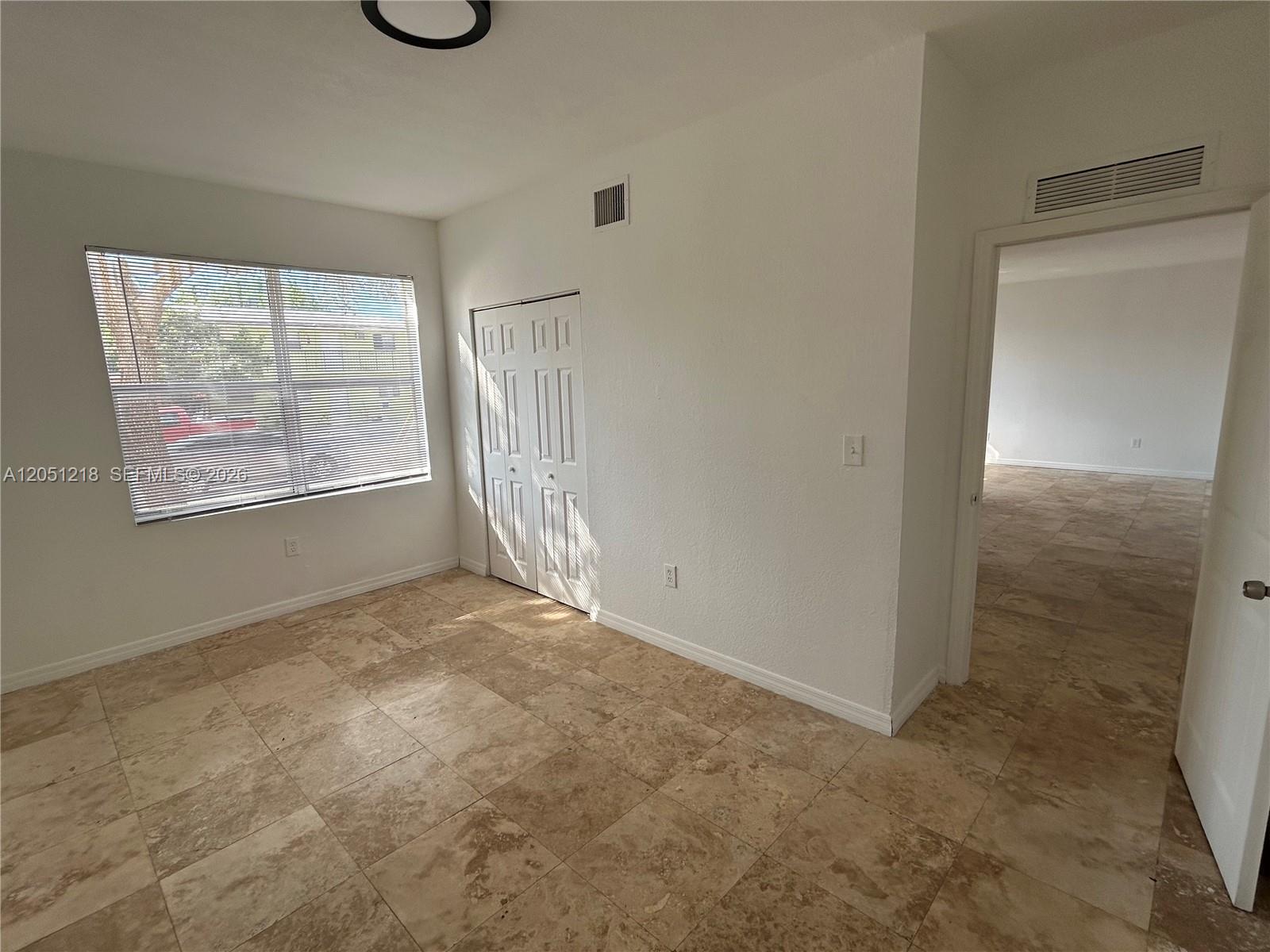A room with white walls, tile flooring, a window with blinds, and a closet door — 953 SW 10th St # 3, Miami FL 33130, MIAMI, FL