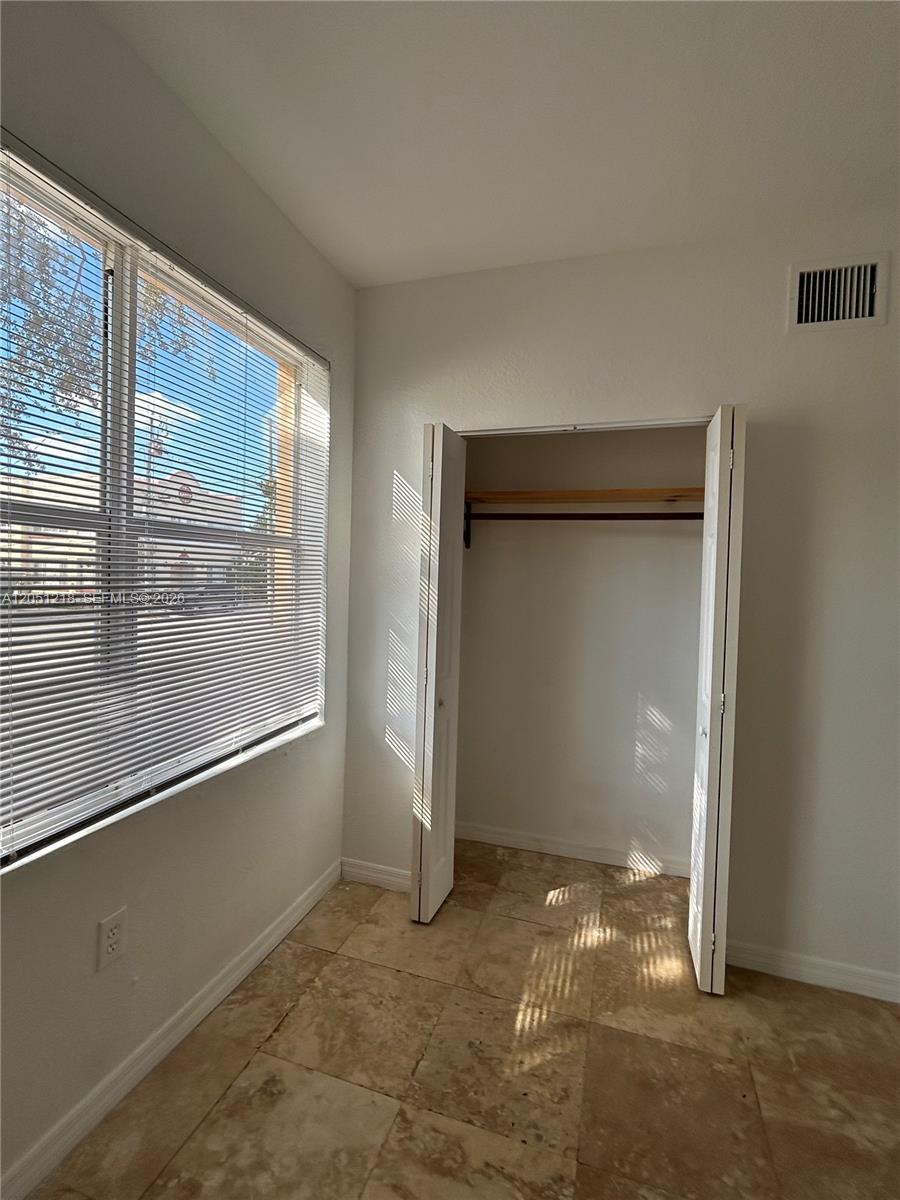 A small room features tile flooring, a window with blinds, and an open closet — 953 SW 10th St # 3, Miami FL 33130, MIAMI, FL