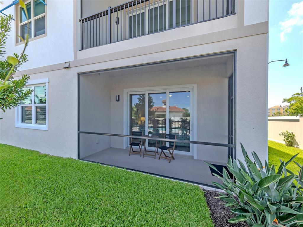 A three-story apartment building stands behind a rectangular swimming pool with a paved deck — 787 S. TAMIAMI TRAIL UNIT 301, VENICE, FL