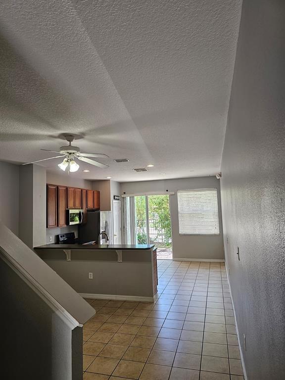 The exterior entrance features a dark green front door and a concrete porch — 5116 DOMINICA DRIVE, KISSIMMEE, FL