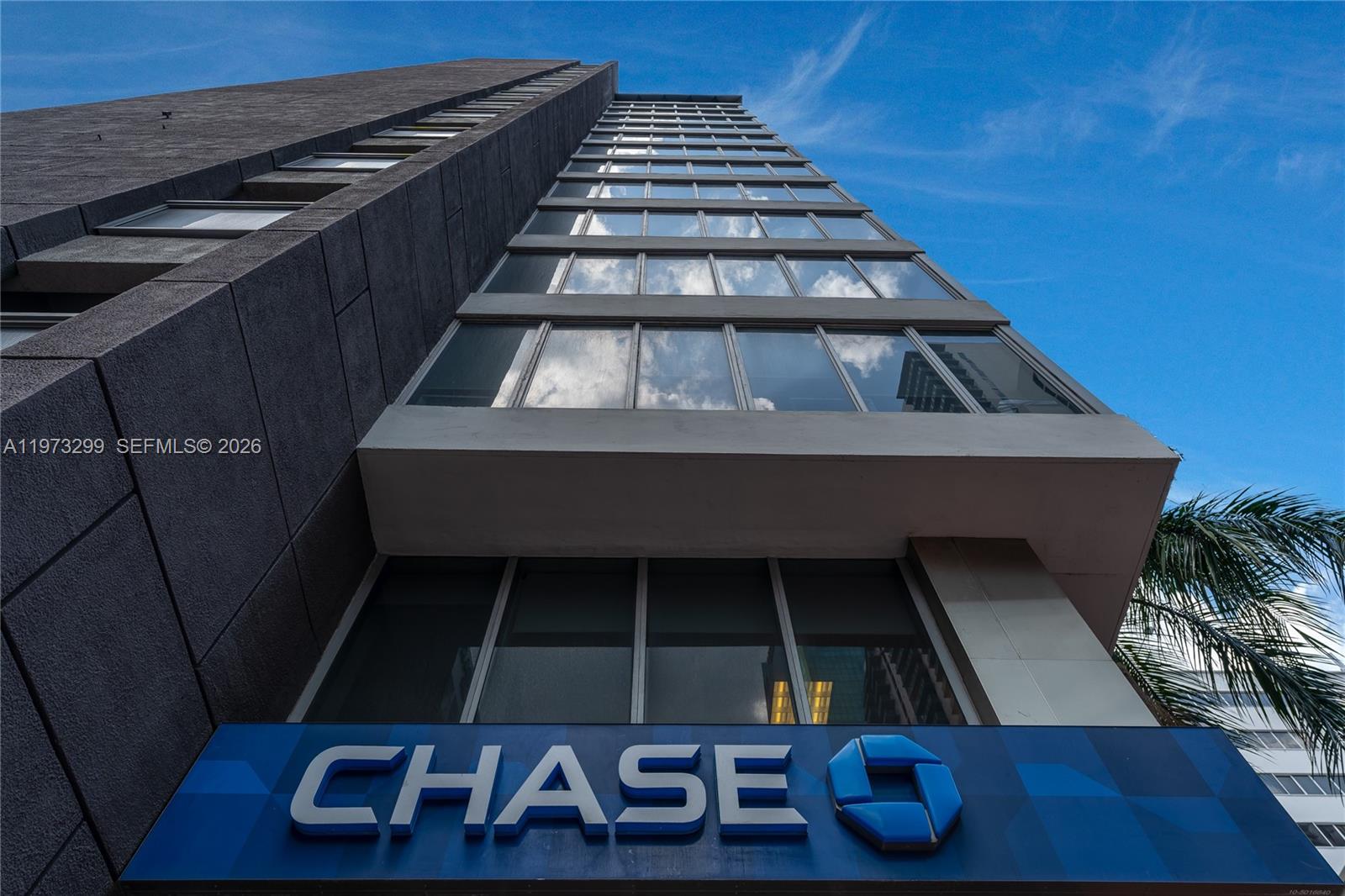 A low-angle exterior view of a tall building featuring a Chase bank sign — 150 SE 2nd Ave # 1401, Miami FL 33131, MIAMI, FL