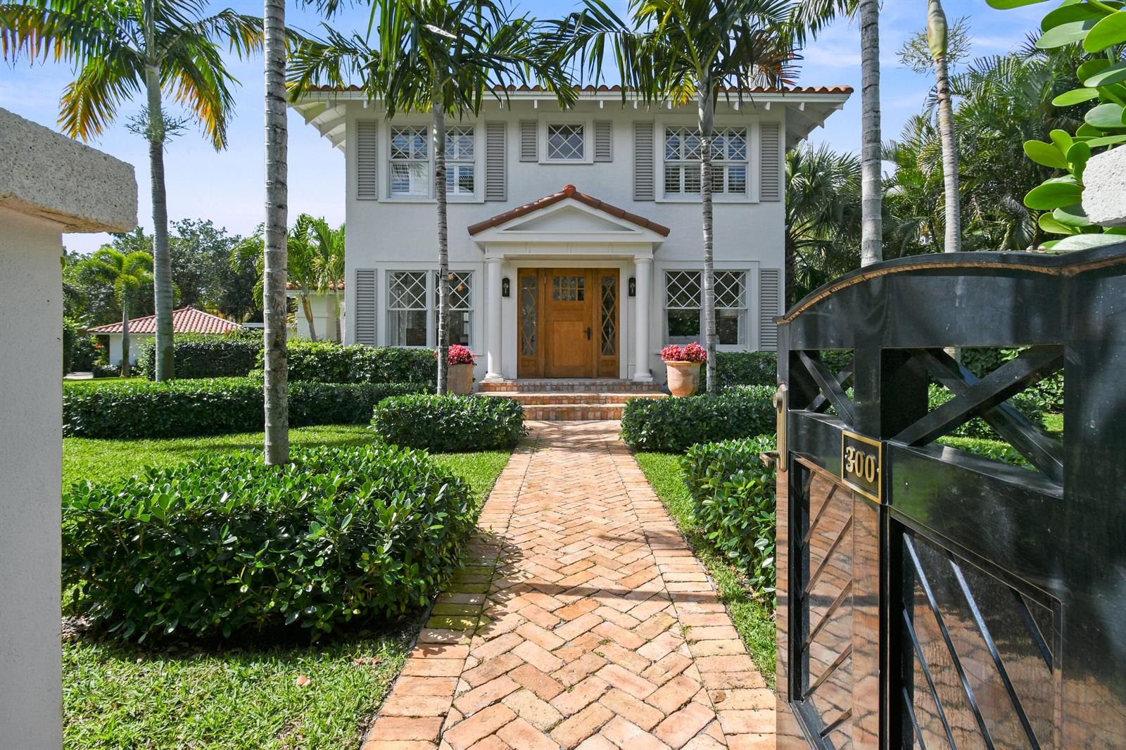 A two-story house with a brick walkway, palm trees, and a black metal gate — 300 Buckingham Road, West Palm Beach FL 33405, WEST PALM BEACH, FL