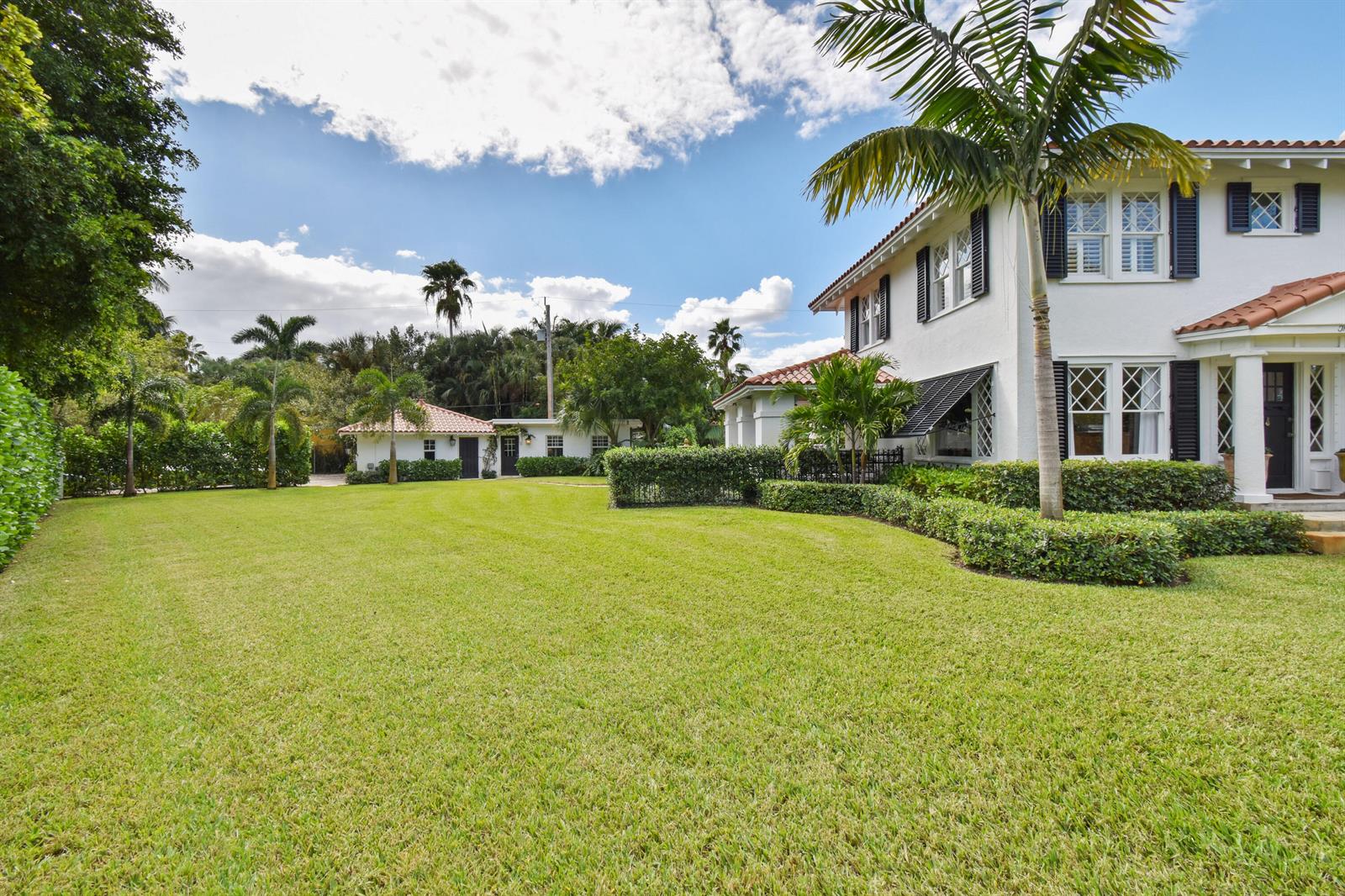 A white two-story house with a red tile roof sits beside a large green lawn — 300 Buckingham Road, West Palm Beach FL 33405, WEST PALM BEACH, FL