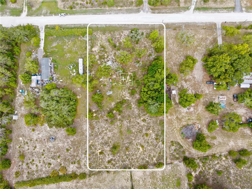 An aerial view shows a rectangular, undeveloped plot of land surrounded by trees and vegetation — 0 FULMAR ROAD, WEEKI WACHEE, FL