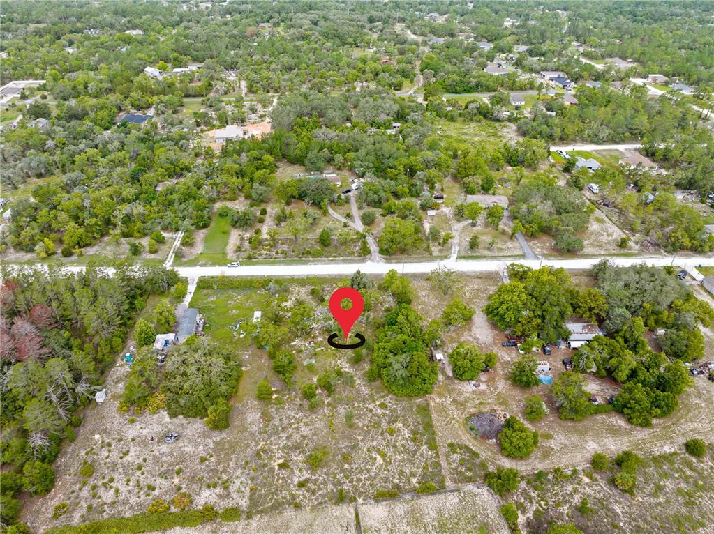 An aerial view shows a vacant, wooded lot marked with a red pin — 0 FULMAR ROAD, WEEKI WACHEE, FL