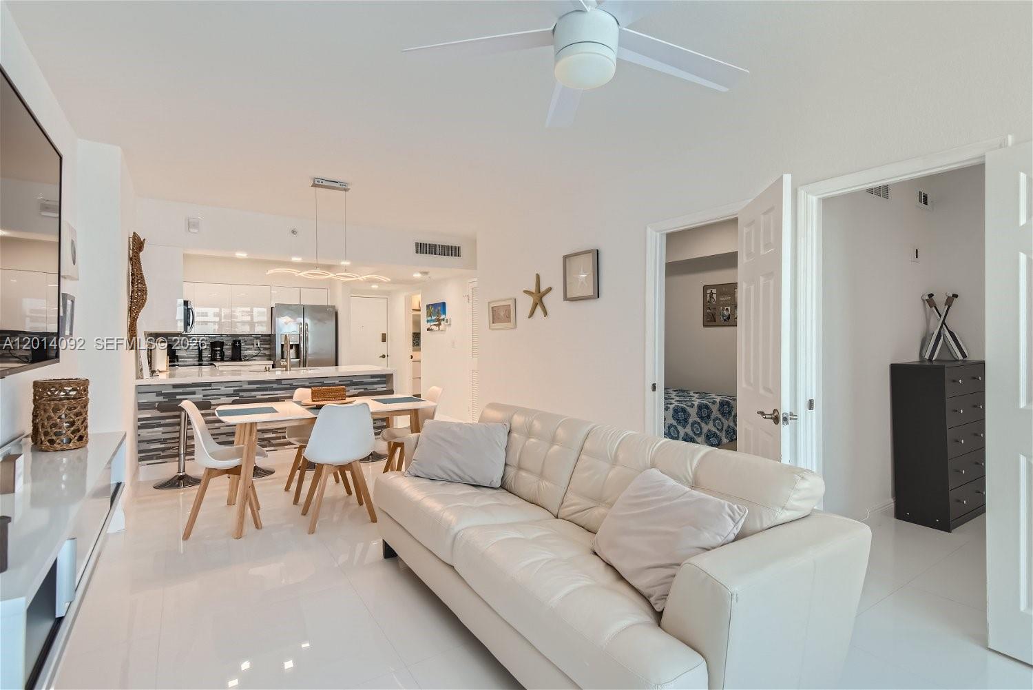 A living room with a white sofa leads to a kitchen with a dining area — 2501 S Ocean Dr # 1103, Hollywood FL 33019, HOLLYWOOD, FL