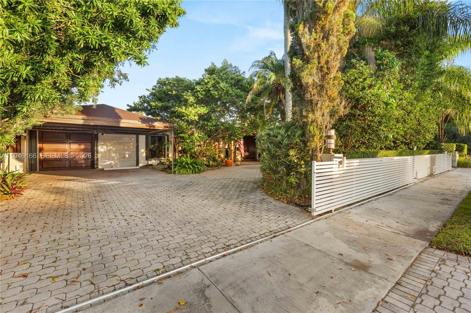 A paved driveway leads to a house with a garage and a white fence — 8115 SW 92nd Ct, Miami FL 33173, MIAMI, FL