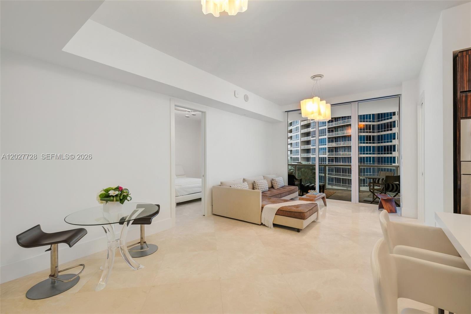 A bright living room features a glass dining table, beige sectional sofa, and floor-to-ceiling windows — 50 S Pointe Dr # 903, Miami Beach FL 33139, MIAMI BEACH, FL
