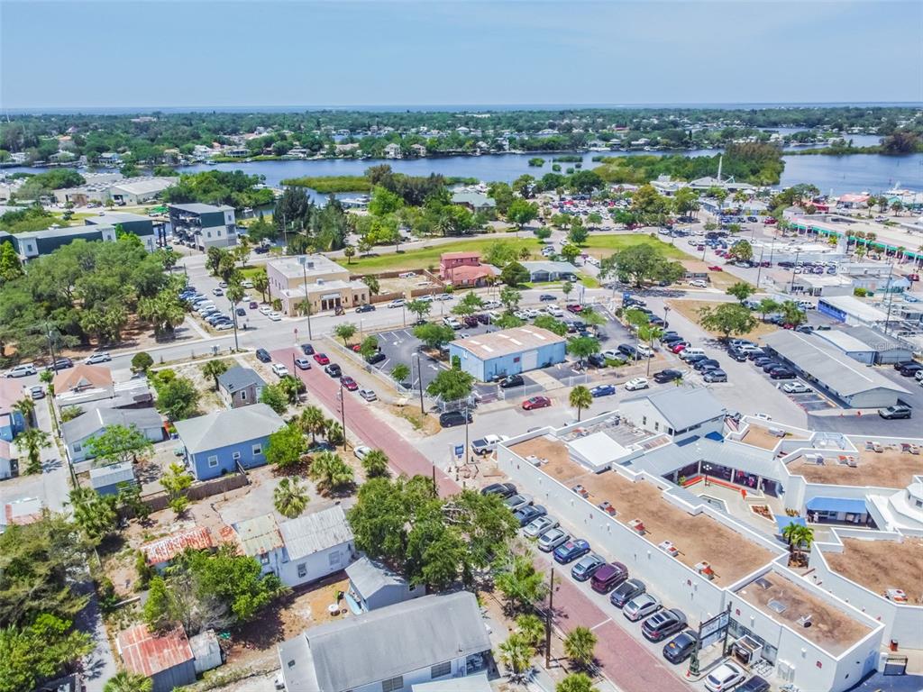 An aerial view shows a coastal town with buildings, parking lots, and a nearby waterway — 00 ATHENS, TARPON SPRINGS, FL