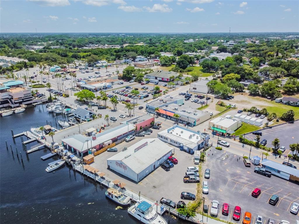 An aerial view shows a waterfront commercial area with boat slips, parking lots, and buildings — 00 ATHENS, TARPON SPRINGS, FL