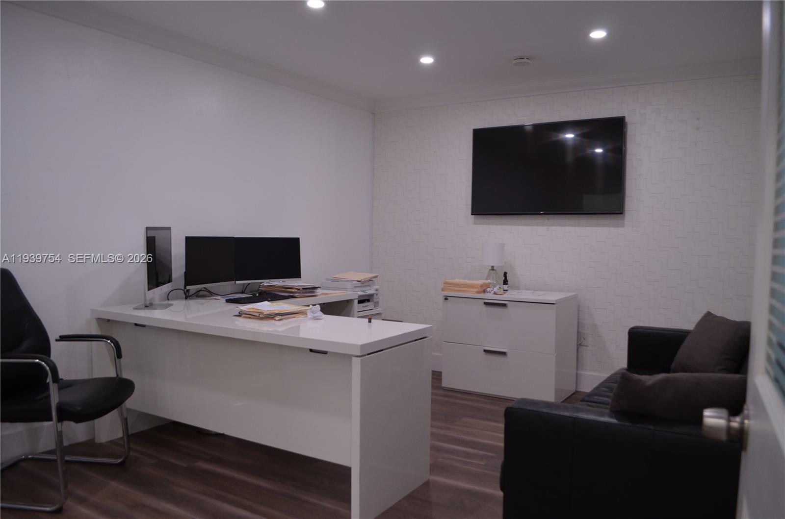 A modern home office features a white desk, a filing cabinet, and a wall-mounted television — 7311 NW 12th St # 20, Miami FL 33126, MIAMI, FL