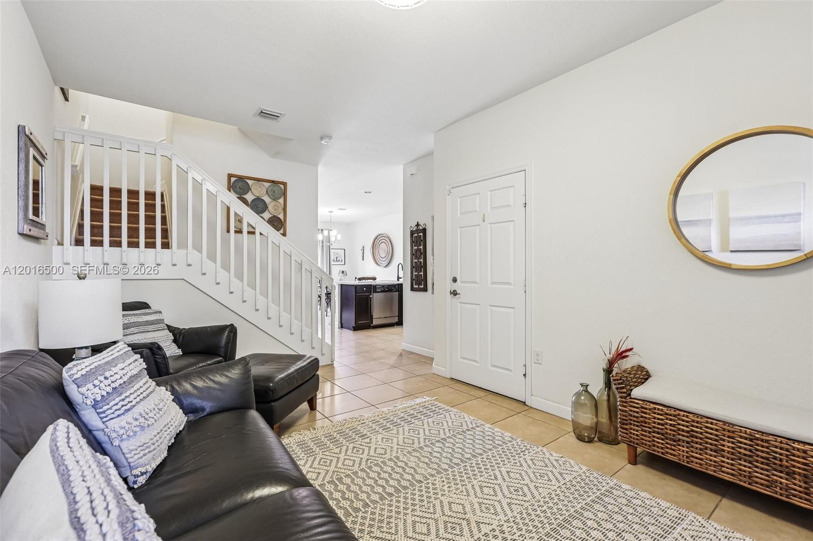 A living room features a staircase, a leather sofa, and a white front door — 284 SE 37th Ter, Homestead FL 33033, HOMESTEAD, FL