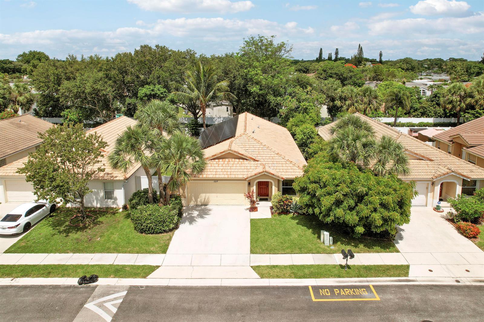 An aerial view of a suburban house with a tiled roof and solar panels — 1017 Fosters Mill Road, Boynton Beach FL 33436, BOYNTON BEACH, FL