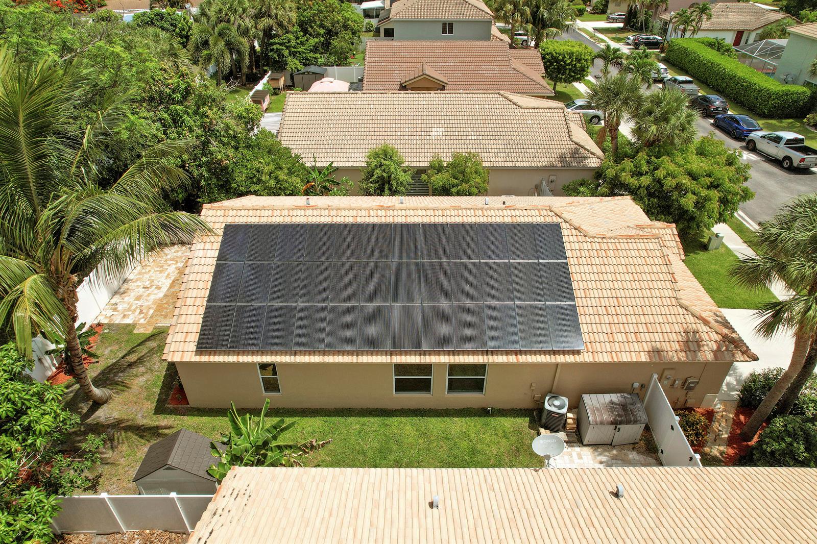 An aerial view shows a house with a large solar panel array on its tiled roof — 1017 Fosters Mill Road, Boynton Beach FL 33436, BOYNTON BEACH, FL
