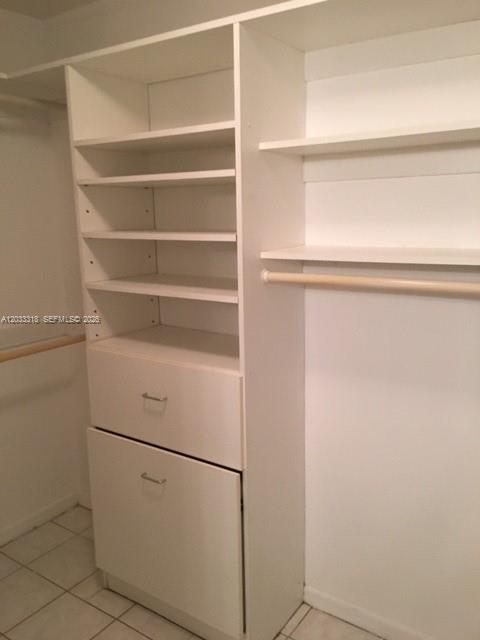 A white closet organizer features open shelving, two drawers, and a hanging rod — MIAMI, FL