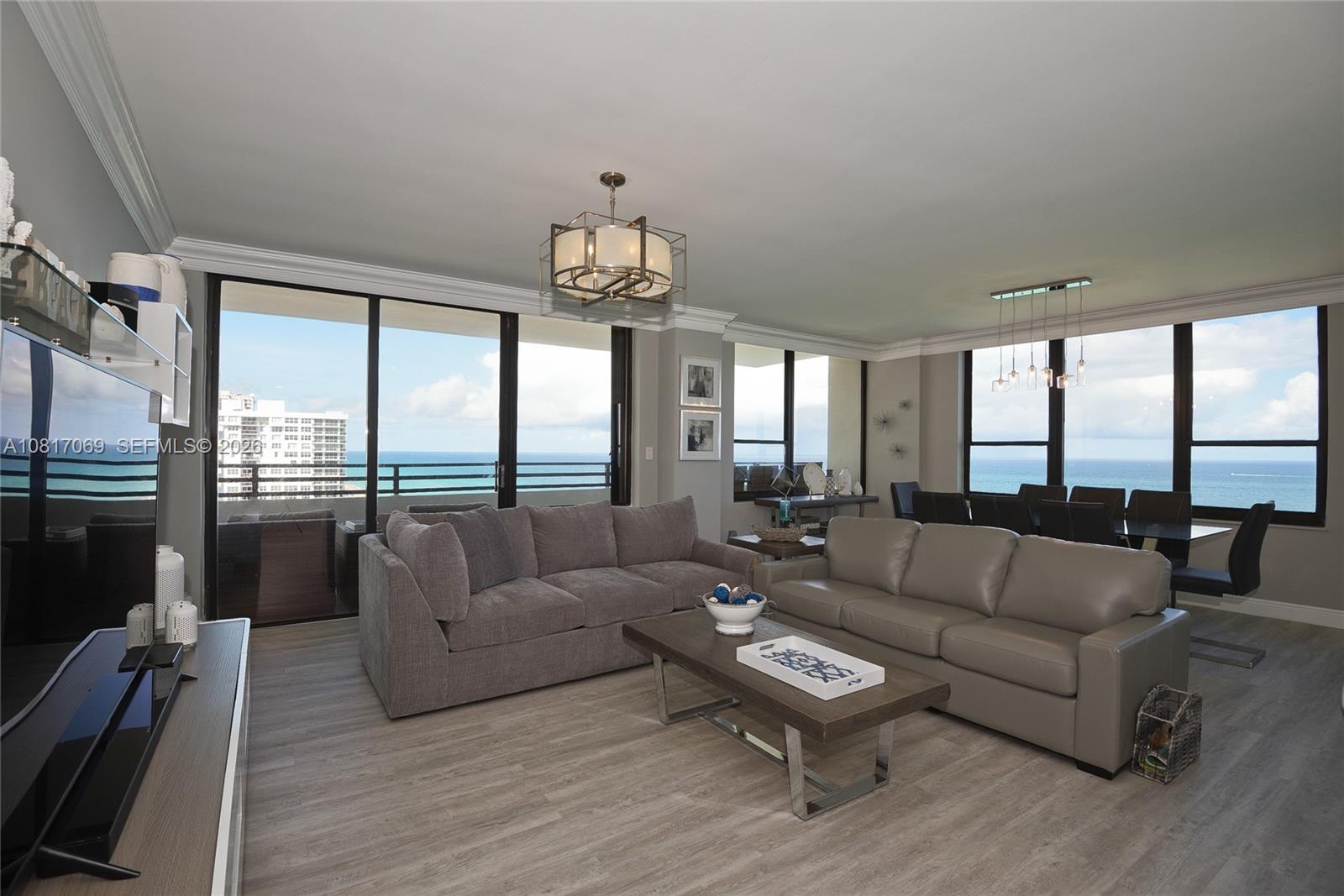 A living room features two sofas, a coffee table, and floor-to-ceiling windows overlooking the ocean — 3505 S Ocean Dr # 12, Hollywood FL 33019, HOLLYWOOD, FL