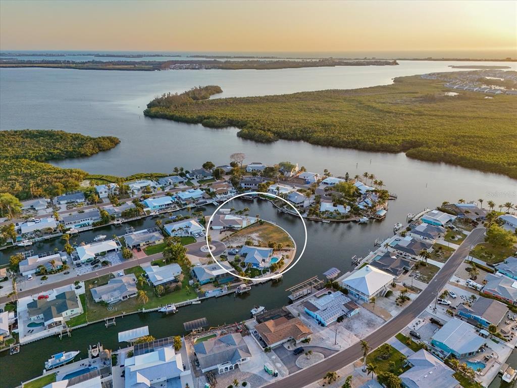 An aerial view shows a waterfront residential lot with a house and pool — 10412 KINGFISHER ROAD W, BRADENTON, FL