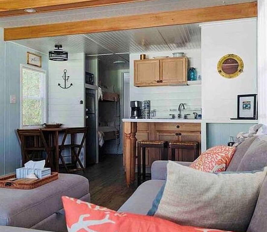 A small living area features a kitchen with wooden cabinets, a breakfast bar, and bunks — 3721 116TH STREET W, BRADENTON, FL