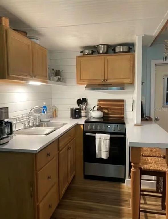 A kitchen features light wood cabinets, white shiplap walls, a stainless steel stove, and countertops — 3721 116TH STREET W, BRADENTON, FL