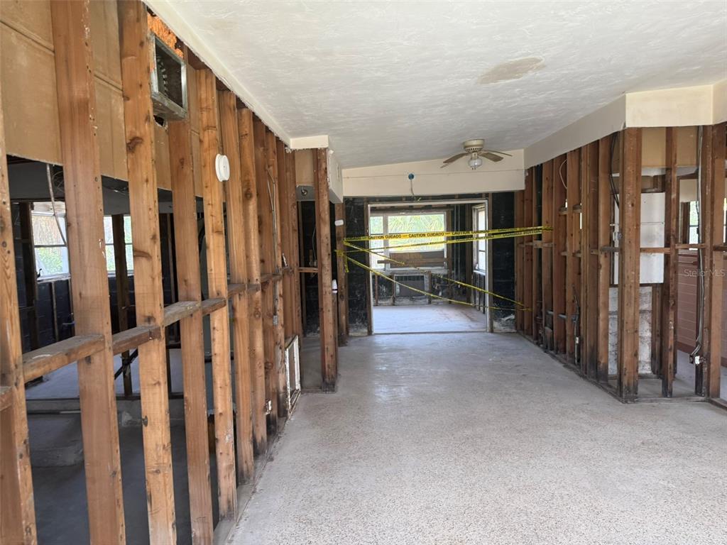 An interior view of a room under renovation with exposed wall studs and concrete flooring — 14054 VIVIAN DRIVE, MADEIRA BEACH, FL