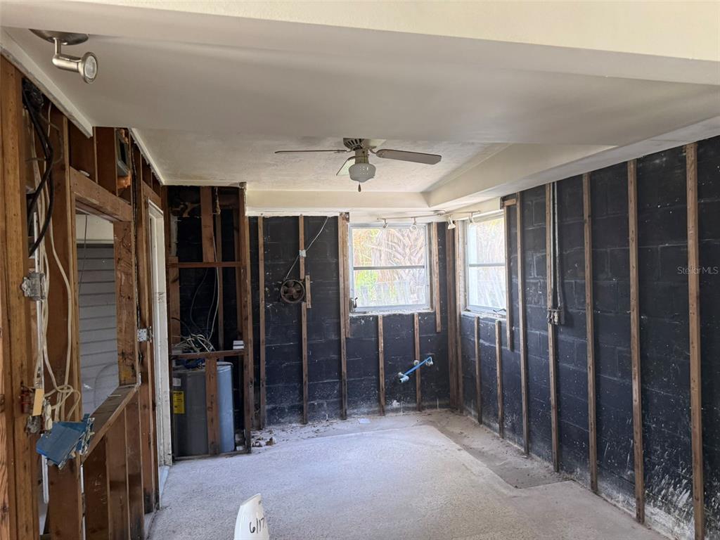 An unfinished room with exposed wall studs, black block walls, and a ceiling fan — 14054 VIVIAN DRIVE, MADEIRA BEACH, FL
