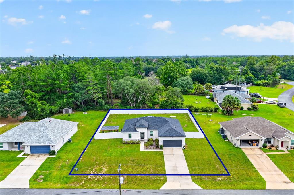 An aerial view shows a single-story house with a fenced backyard and a concrete driveway — 149 MARION OAKS GOLF ROAD, OCALA, FL