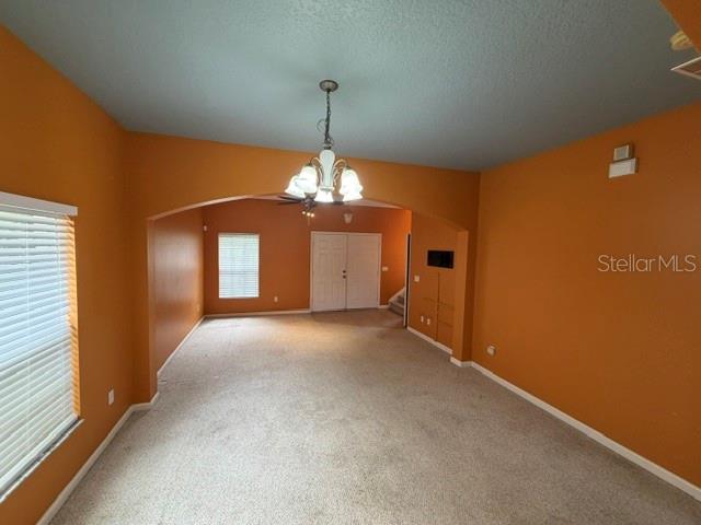 A carpeted living room features orange walls, a chandelier, and an arched entryway — 9118 SABAL PINE WAY, ORLANDO, FL