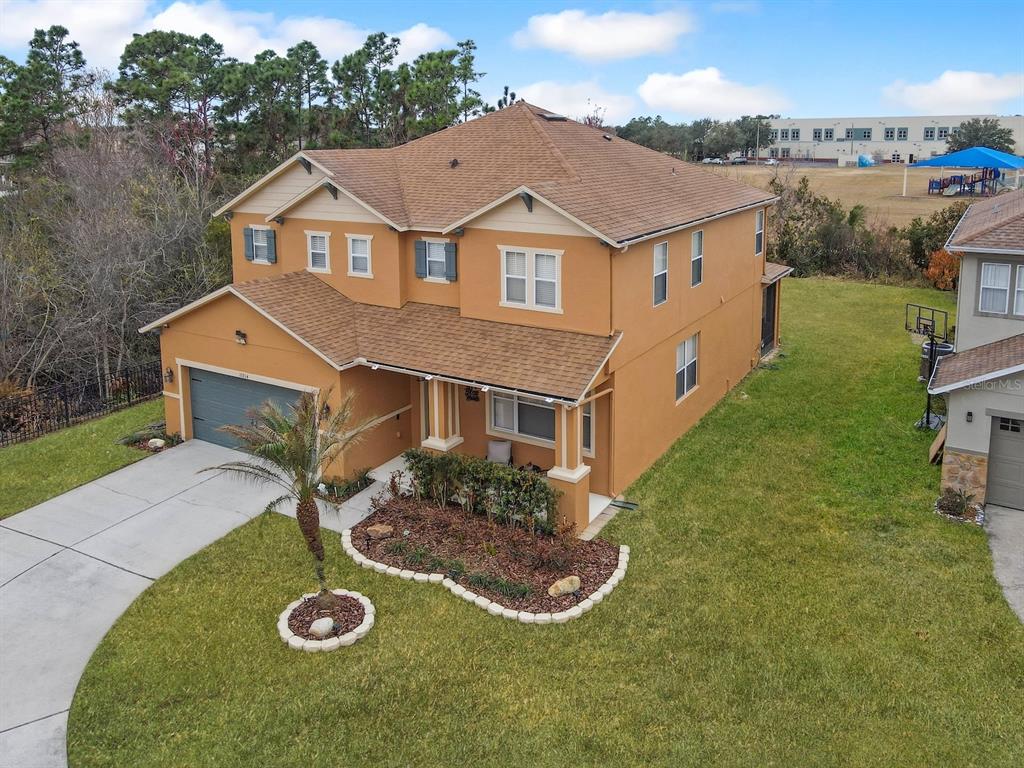 An aerial view of a two-story tan house with a brown roof and front landscaping — 15214 GALBI DRIVE, ORLANDO, FL