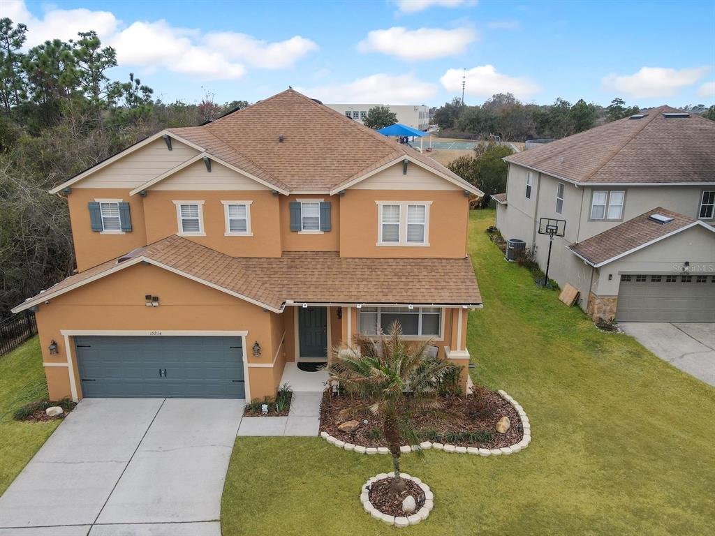 An aerial view of a two-story suburban house with a tan exterior and brown roof — 15214 GALBI DRIVE, ORLANDO, FL