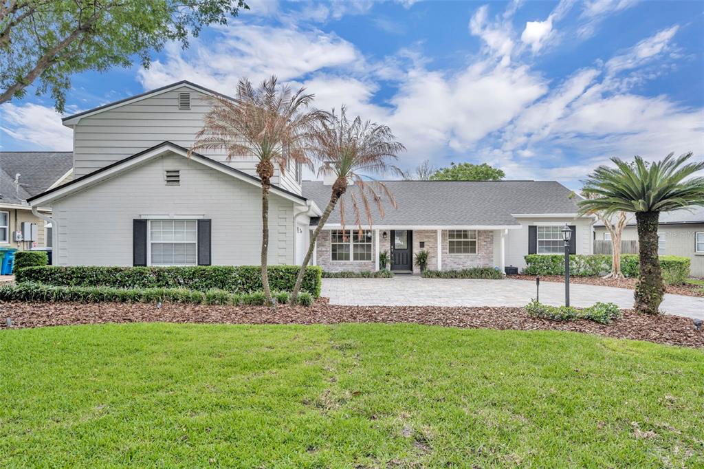 A two-story house with a light gray exterior, stone accents, and a paved front driveway — 2112 CHIPPEWA TRAIL, MAITLAND, FL