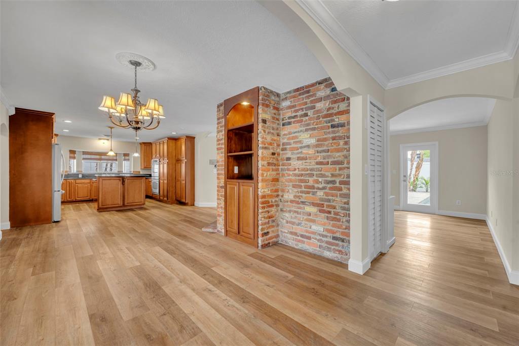 A kitchen and dining area feature wood flooring, a brick accent wall, and wooden cabinetry — 2112 CHIPPEWA TRAIL, MAITLAND, FL