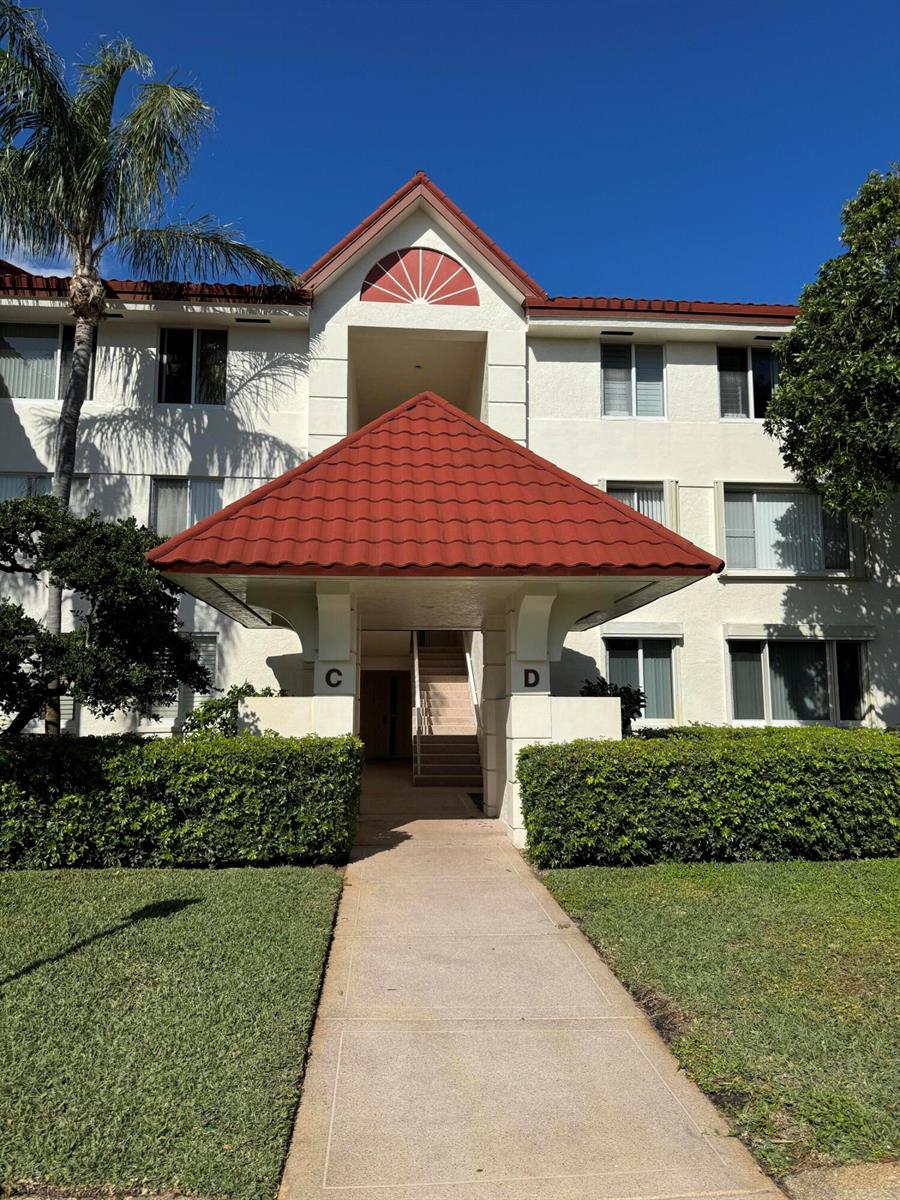 A multi-story apartment building with a red tile roof and a central covered entryway — 110 Half Moon Circle # C1, Hypoluxo FL 33462, HYPOLUXO, FL