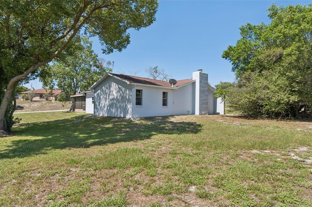 A single-story house with a white exterior, stone accents, and an attached garage — 10200 SUNBURST COURT, SPRING HILL, FL