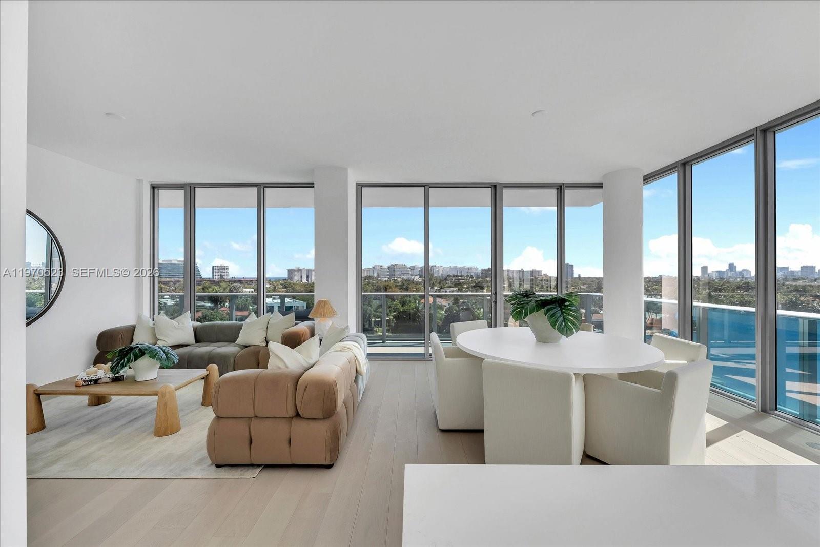 A bright living and dining area features floor-to-ceiling windows with views of the city — 9201 E Bay Harbor Dr, Bay Harbor Islands FL 33154, BAY HARBOR ISLANDS, FL