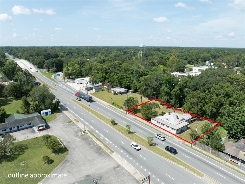 An aerial view shows a house outlined in red situated along a multi-lane highway — 14962 NE US HIGHWAY 301, WALDO, FL