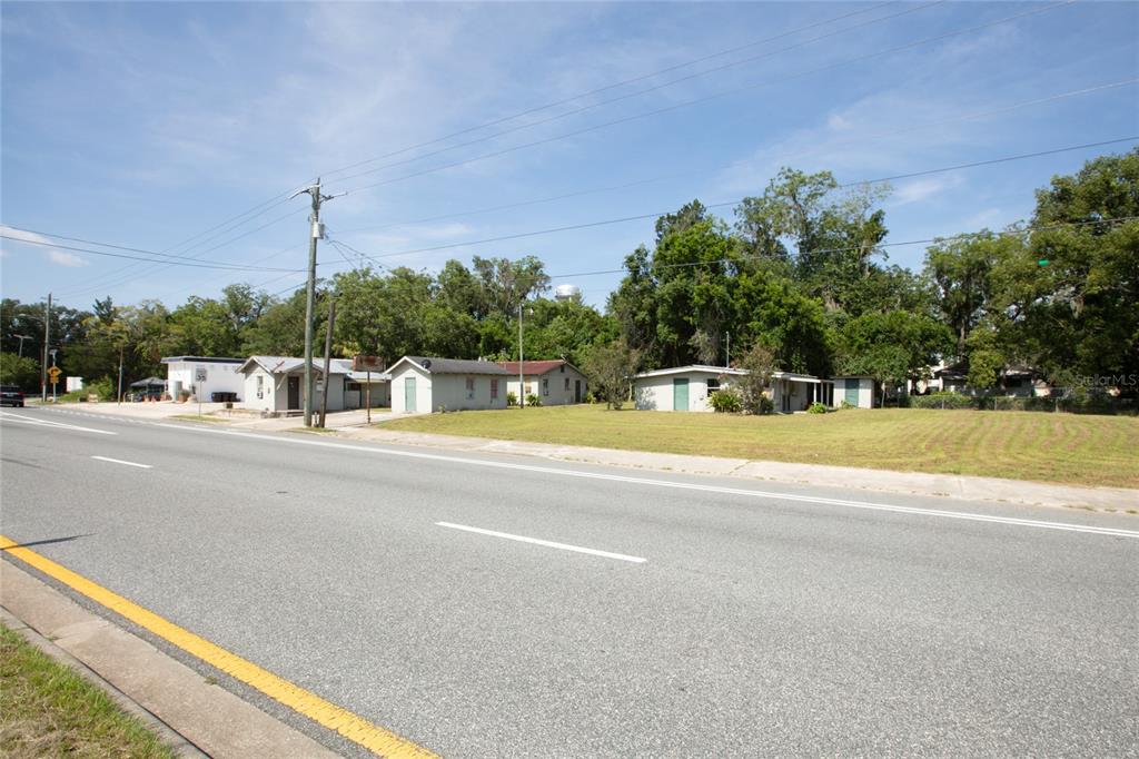 A street-level view shows a row of small, single-story houses along a paved road — 14962 NE US HIGHWAY 301, WALDO, FL