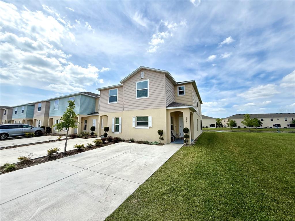 A two-story townhouse with a beige stucco lower level and tan siding upper level — 4910 CORAL CASTLE DRIVE, KISSIMMEE, FL