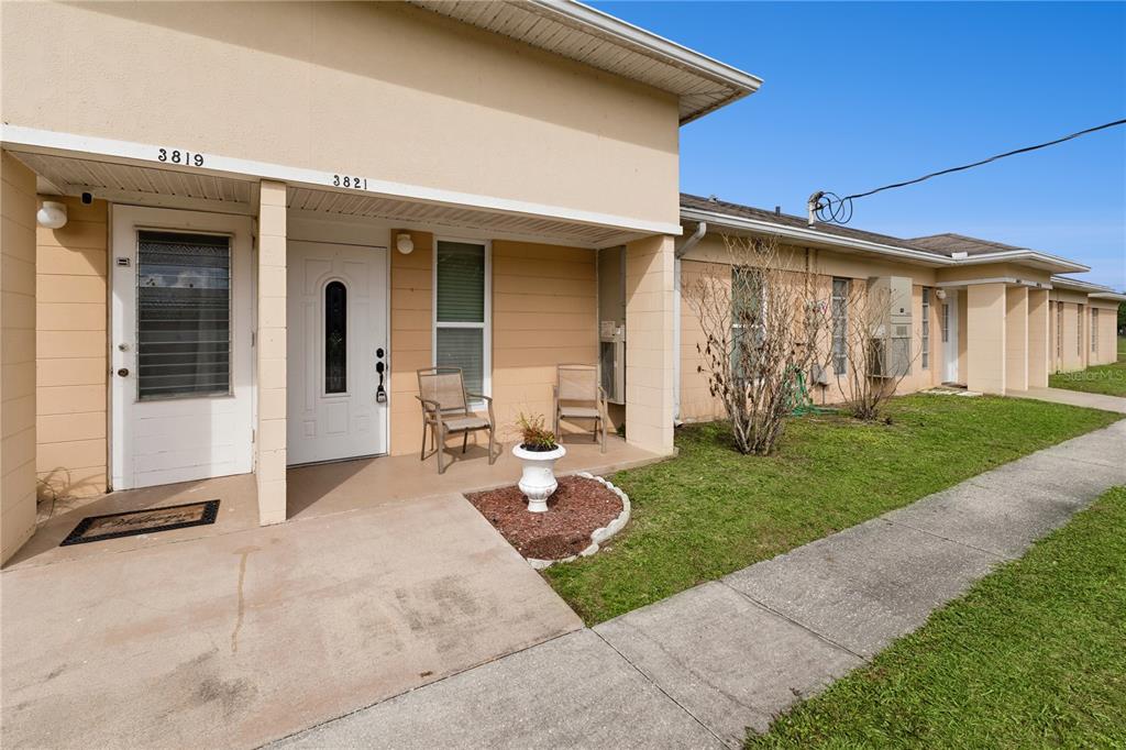A tan exterior building features two adjacent front entrances with a shared concrete walkway — 3821 CLUB CIRCLE, LAKE WALES, FL