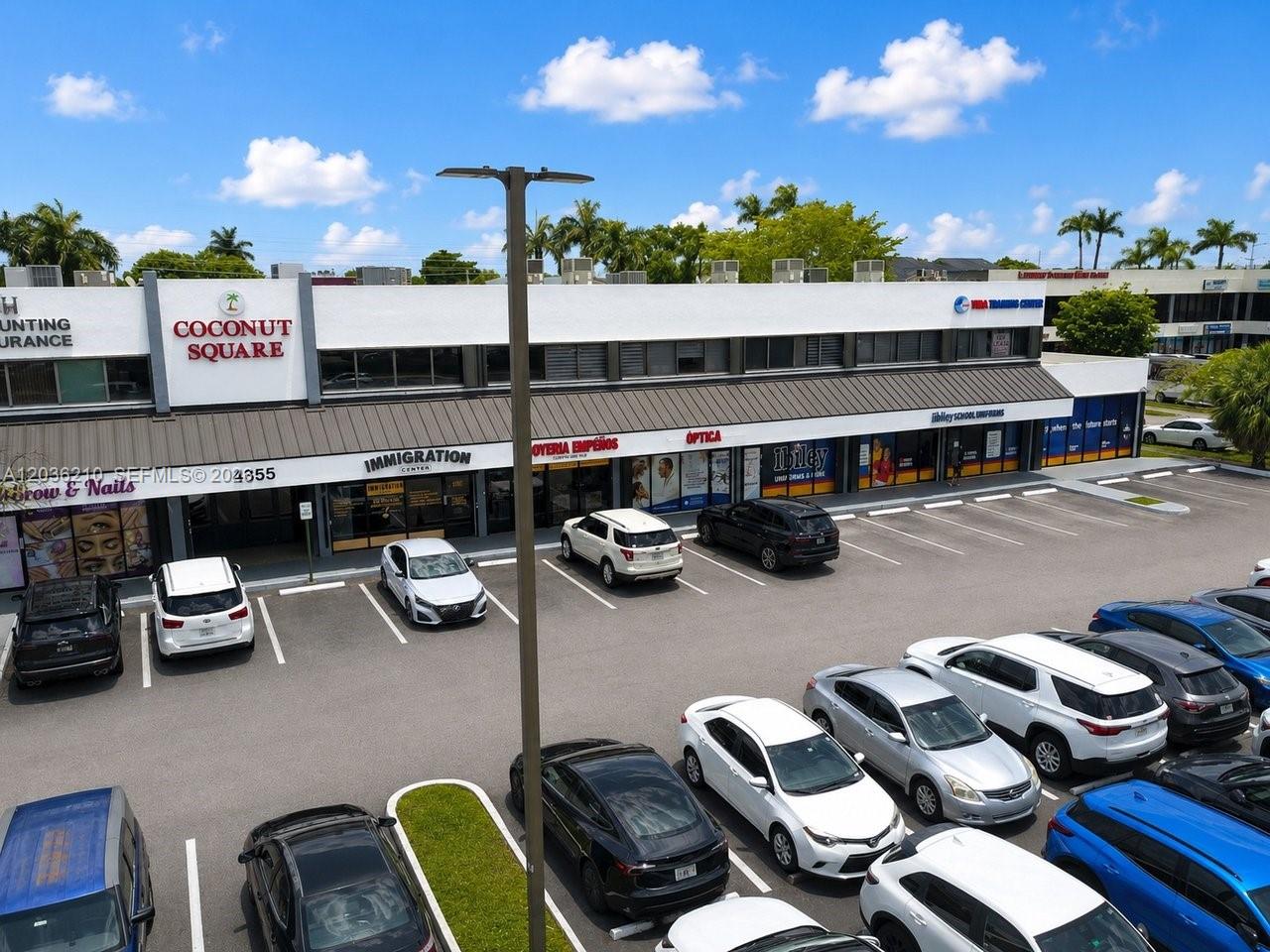 An exterior view of a two-story commercial building named Coconut Square with a parking lot — 4355 W 16th Ave, Hialeah FL 33012, HIALEAH, FL