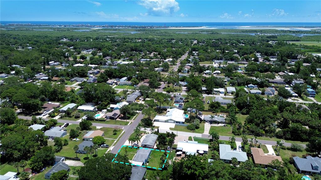 An aerial view shows a residential neighborhood with a highlighted property lot and surrounding homes — 903 CONRAD DRIVE, NEW SMYRNA BEACH, FL