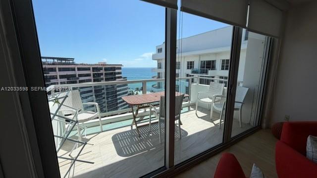 A balcony with a dining set overlooks the ocean and neighboring buildings — 5161 Collins Ave # 1702, Miami Beach FL 33140, MIAMI BEACH, FL